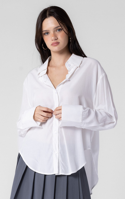 This model is wearing a long sleeve button down in white.
