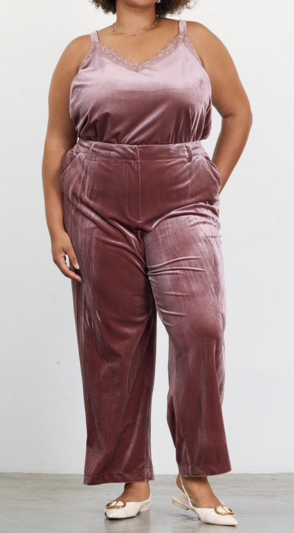 A model wearing mauve crushed velvet pants with a V-neckline top.